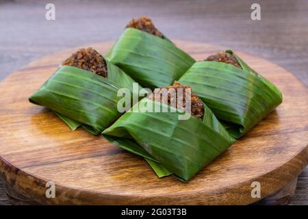 Kuih Pulut inti, dessert malaisien traditionnel. Riz gluant salé à la noix de coco râpée sucrée enveloppée de feuille de banane Banque D'Images