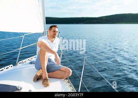 Happy Man assis sur la terrasse en bateau pour profiter de la promenade en mer Banque D'Images