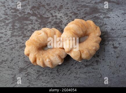 Vue de dessus de deux beignets en forme de beignet sur un fond gris tacheté. Banque D'Images