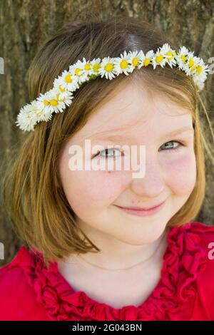 Fille de six ans avec une guirlande sur sa tête en forme de couronne. ROYAUME-UNI. (123) Banque D'Images