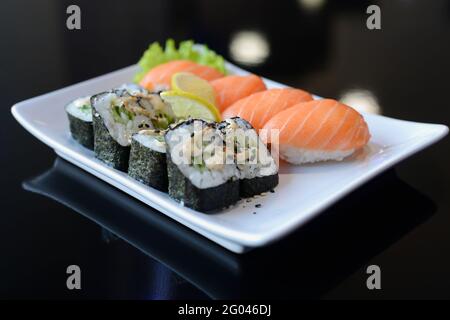 Petits pains à sushis sur un plat blanc. Cuisine japonaise. Banque D'Images