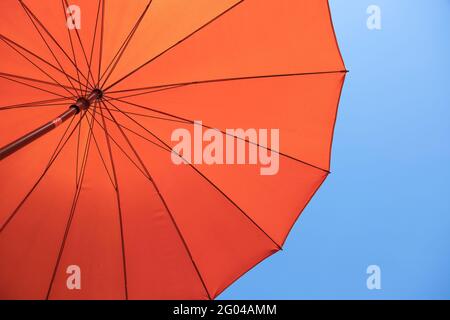 parasol orange sous ciel bleu Banque D'Images