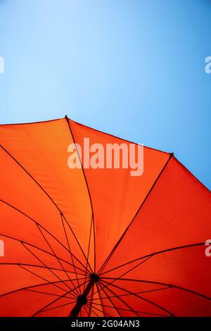 parasol orange sous ciel bleu Banque D'Images