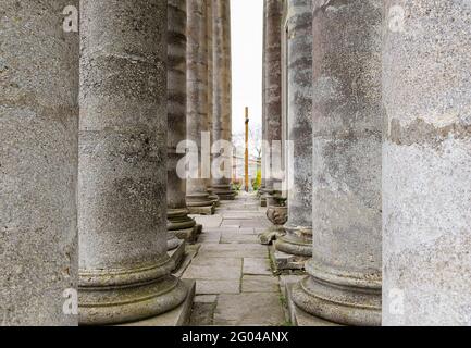 Passage secret, deux longues rangées de colonnes anciennes en pierre partout, un tunnel. Lignes de colonnes. Monument architectural. Banque D'Images