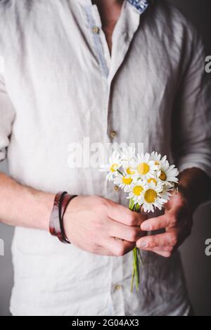 Bouquet de fleurs fraîchement cueillies aux mains de mâles Banque D'Images