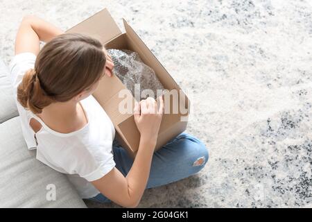 Jeune femme déballage de colis à la maison Banque D'Images