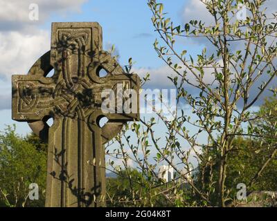 Gros plan du motif ornementé dans une croix celtique en pierre sur une pierre de pierre dans un cimetière écossais. Banque D'Images