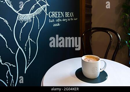 Saint-Pétersbourg, Russie - 25 mai 2021 : café Starbucks sur une table de café et rue bruyante derrière la fenêtre Banque D'Images