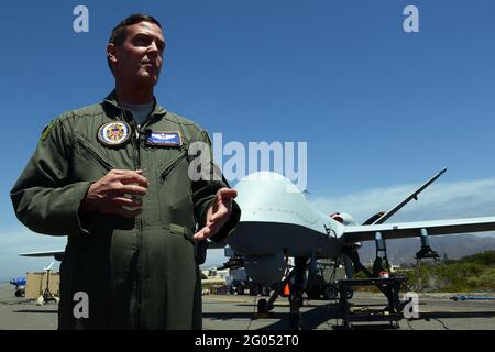 Reportage : le major de la Force aérienne Scott Gregg, officier de projet de Black Dart, parle aux médias devant un système d'avions sans pilote MQ-9 Reaper, à la base navale du comté de Ventura et de la chaîne de tir maritime, point Mugu, en Californie, le 31 juillet 2015. Le drone, dit Gregg, fait partie des plus grandes catégories d'UAS, ou Groupe 5, vole à plus de 18,000 pieds et pèse plus de 1,300 livres. Il a été utilisé dans le cadre de la démonstration de deux semaines de Black Dart Counter-UAS, du 26 juillet au 1er août, pour évaluer et améliorer les technologies, tactiques et techniques utilisées par le DoD et ses partenaires. Banque D'Images