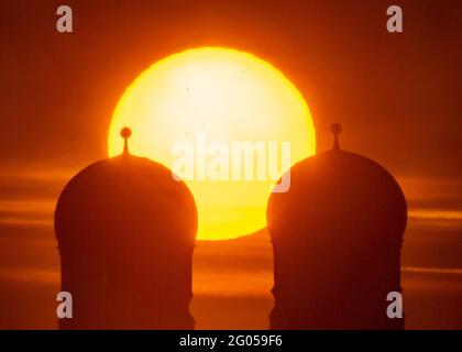 Munich, Allemagne. 1er juin 2021. Le soleil se lève tôt le matin entre les deux tours de 99 mètres de haut de la Frauenkirche, qui se trouve au coeur de la capitale bavaroise. La photo a été prise avec un téléobjectif de 1120 millimètres de la Theresienwiese. Credit: Peter Kneffel/dpa/Alay Live News Banque D'Images