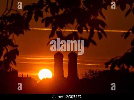 Munich, Allemagne. 1er juin 2021. Le soleil se lève tôt le matin entre les deux tours de 99 mètres de haut de la Frauenkirche, qui se trouve au coeur de la capitale bavaroise. La photo a été prise avec un téléobjectif de 360 millimètres de la Theresienwiese. Credit: Peter Kneffel/dpa/Alay Live News Banque D'Images