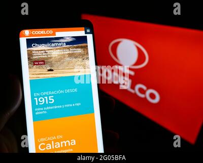 Personne tenant un téléphone mobile avec le site Web de la société minière chilienne Codelco à l'écran devant le logo de l'entreprise. Concentrez-vous sur le centre de l'écran du téléphone. Banque D'Images