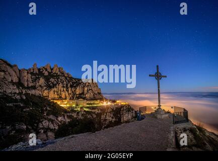 Creu de Sant Miquel Vewpoint, à Montserrat, la nuit, avec une mer nocturne de nuages - brouillard (Barcelone, Catalogne, Espagne) Banque D'Images