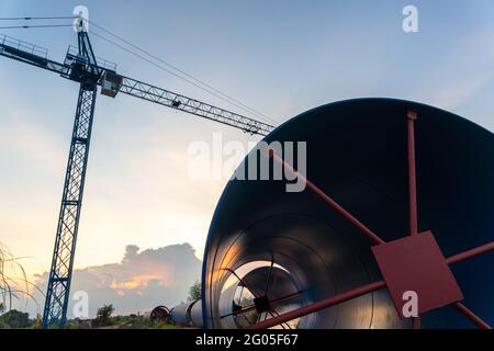 Grue de construction pour la pose de grands tuyaux en acier pour le projet d'eau potable en planification urbaine, grands tuyaux en acier sur le chantier de construction Banque D'Images