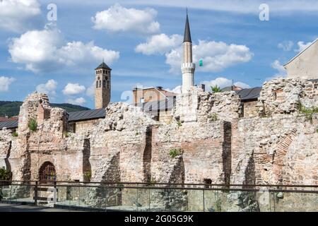 Ruines historiques de Taslihan (Caravanserai en pierre) avec vue sur la Tour de l'horloge et le minaret de la mosquée de Gazi Husrev-begova, les Bascars Banque D'Images