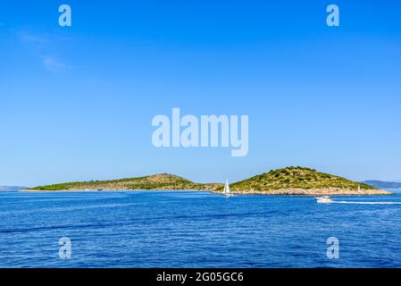 Côte Adriatique avec plage rocheuse, petites îles, bateaux et yachts à voile dans la mer bleue, Croatie, Dalmatie Banque D'Images