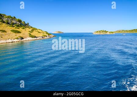 Côte Adriatique avec plage rocheuse, petites îles, bateaux et yachts à voile dans la mer bleue, Croatie, Dalmatie Banque D'Images