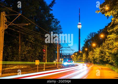 Allemagne, voitures passant par la tour de télévision et la rue animée de stuttgart dans la forêt verte paysage de la nature dans une ambiance magique crépuscule après le coucher du soleil Banque D'Images