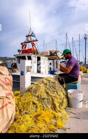 FINIKAS, SIROS, Grèce, 27.05.2019. Pêcheur grec réparant ses filets de pêche en nylon sur le quai de Port de Finikas sur l'île de Siros, Cyclades, Grèce. Banque D'Images