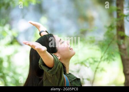 Jeune femme voyageur avec une nature verte détente dans le parc. Femme asiatique souriant et regarde la caméra. Concept de voyage Banque D'Images