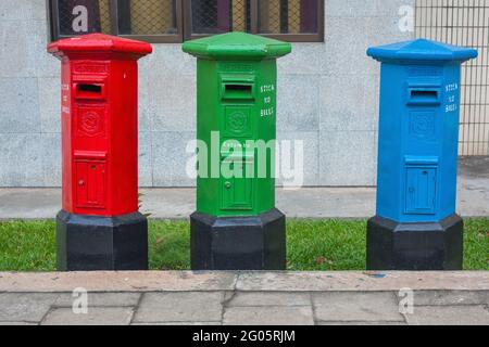 Trois boîtes postales de la collection Royal Mail de couleur rouge, verte et bleue sur le trottoir à Colombo, Sri Lanka Banque D'Images