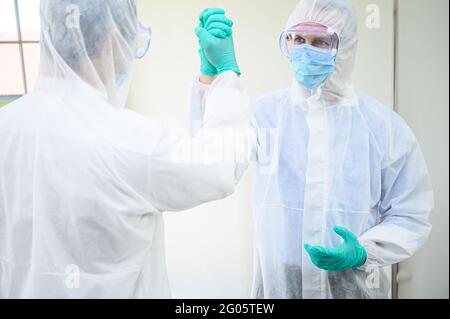 Couple scientifique masculin portant un costume de protection poignée de main pour réussir le travail d'équipe en laboratoire. Portrait du scientifique Banque D'Images