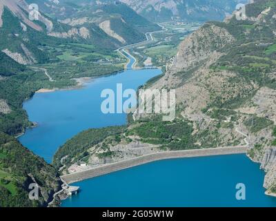 VUE AÉRIENNE.Barrage du lac de serre-Ponçon avec le canal EDF et la Durance au loin.France. Banque D'Images