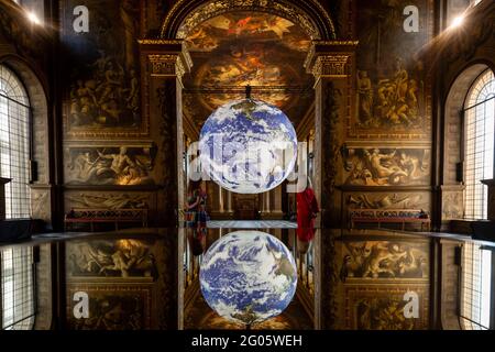 Londres, Royaume-Uni, 1er juin 2021. Le personnel de l’artiste Luke Jerram “Gaia” qui a été installé dans la salle Painted du Old Royal Naval College de Greenwich. La réplique de l'échelle de la Terre tourne lentement pour inspirer un sentiment de l'effet de vue d'ensemble que les astronautes éprouvent lorsqu'ils voient la Terre depuis l'espace. Le travail est exposé jusqu'au 1er juillet. Credit: Stephen Chung / Alamy Live News Banque D'Images