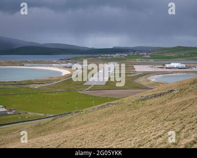 Par une journée nuageux et couvert, vue sur la piste 15-33 de l'aéroport de Sumburgh entre deux plages au sud de Shetland, au Royaume-Uni. Banque D'Images