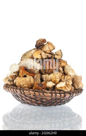 Tas de champignons secs dans une assiette en bois. Isolé sur fond blanc. Banque D'Images