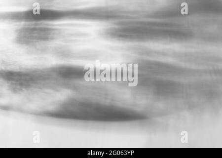 Le verre laisse tomber l'ombre diagonale et la lumière caustiques sur un mur blanc. Caustiques formées par la réfraction du soleil dans une bouteille sur une table lumineuse. Rayons, Banque D'Images