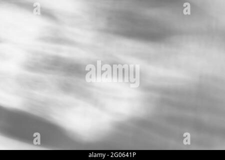 Le verre laisse tomber l'ombre diagonale et la lumière caustiques sur un mur blanc. Caustiques formées par la réfraction du soleil dans une bouteille sur une table lumineuse. Rayons, Banque D'Images