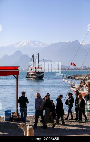 Antalya, Turquie décembre 22 2018: Personnes marchant dans le port de plaisance contre la rive de la mer Méditerranée de la Turquie d'Antalya, taurus montagnes. Banque D'Images