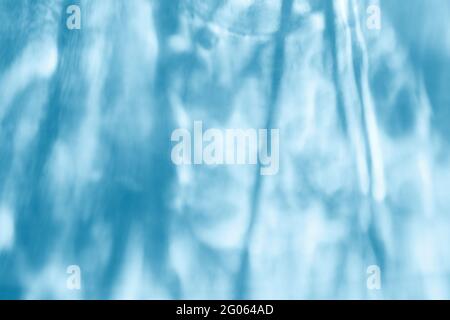 Effet de superposition de texture d'eau pour les photos et les maquettes. Effet caustique de l'ombre et de la lumière organiques en diagonale sur un mur bleu Banque D'Images