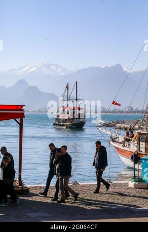 Antalya, Turquie décembre 22 2018: Personnes marchant dans le port de plaisance contre la rive de la mer Méditerranée de la Turquie d'Antalya, taurus montagnes. Banque D'Images