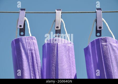 Vue de face de couleur bleue masque chirurgical suspendu sur corde à linge avec épinglette, concept de protéger l'environnement des déchets et de la pollution. Banque D'Images