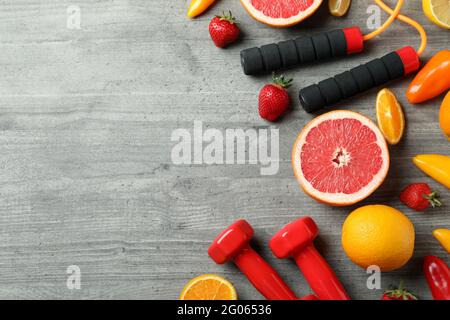 Nourriture saine, corde à sauter et haltères sur fond gris texturé Banque D'Images