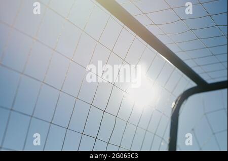 Grille de football en mesh sur fond bleu ciel dans une lumière ensoleillée Banque D'Images