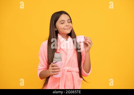 jeune fille rêveuse à la maison en éponge peignoir avec bouteille de thermos, soif Banque D'Images