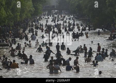 Pakistanais un grand nombre de personnes prenant un bain se baignant à l'intérieur du canal de l'eau pour battre la chaleur et obtenir un peu de soulagement du temps extrêmement chaud que la température a atteint 43 C (111.20 F) à Lahore. Selon le Département météorologique du Pakistan (PMD), le temps est resté chaud et sec dans la plupart des régions du pays, la température maximale est de 43 C(111.20 F) degrés Celsius dans la capitale provinciale de Lahore, au Pakistan, le 30 mai 2021. Les experts ont prévu que les conditions météorologiques extrêmes perdurcissent au cours de la semaine prochaine ; la chaleur sizzante a forcé les gens à rester à l'intérieur, réduisant ainsi la circulation Banque D'Images