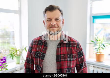 Portrait d'un homme de 40 ans, souriant homme en tissu écossais décontracté regardant l'appareil photo Banque D'Images