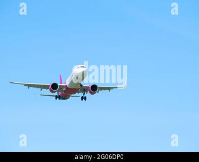 Otopeni, Roumanie - 05.08.2021: Un avion Wizz Air Airbus A321-271NX (HA-LVI) volant avec un ciel bleu clair. Banque D'Images