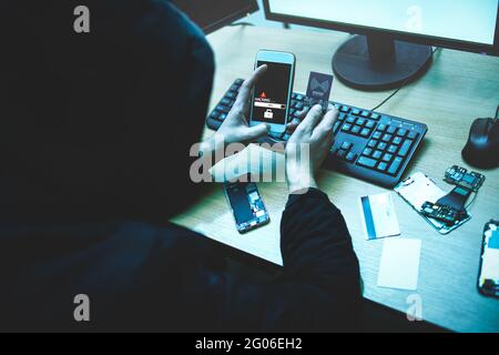 Un pirate tente d'accéder au téléphone. Sécurité et protection des données personnelles. Le concept de cybercriminalité et de piratage de dispositifs électroniques Banque D'Images