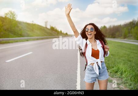 Aventure et tourisme. Belle femme millénaire en tenue décontractée en voiture, en randonnée sur le bord de la route, espace de copie Banque D'Images