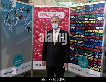 Le roi Philippe - Filip de Belgique pose pour le photographe devant le 'mur de selfie', lors d'une visite royale au centre de vaccination d'BE-Mine i. Banque D'Images