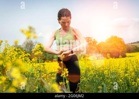 femme sportive utilisant une montre intelligente à l'extérieur dans la campagne Banque D'Images