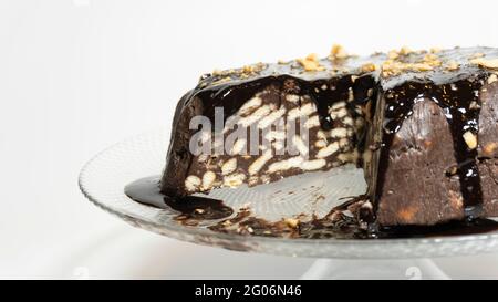 Une tranche de gâteau de mosaïque pris, gâteau de mosaïque avec des morceaux de chocolat et de noisette sur le dessus, arrière-plan blanc isolé, idée de concept alimentaire Banque D'Images