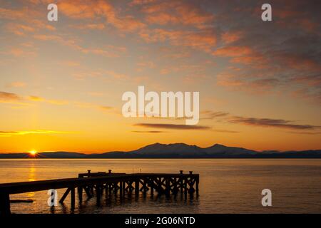 Un magnifique coucher de soleil derrière l'île d'Arran, pris de l'ancien quai de Portencross dans le nord de l'Ayrshire, en Écosse. Banque D'Images