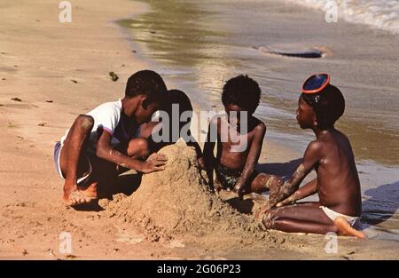 Années 1990 Trinité-et-Tobago - jeunes garçons locaux construisant un château de sable à Tobago ca. 1995 Banque D'Images