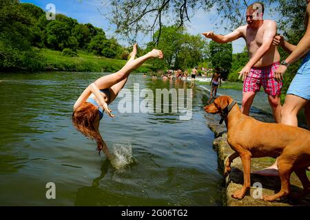 Une femme est jetée dans l'eau tandis que les gens apprécient le temps chaud à Warleigh Weir, Bath, le premier jour de l'été météorologique. Date de la photo: Mardi 1er juin 2021. Banque D'Images